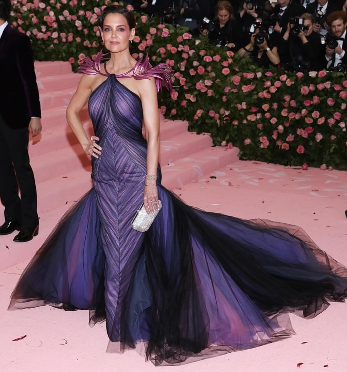 Katie Holmes wore a custom Zac Posen gown with dramatic 3D-printed shoulder details, complemented by custom-dyed Jimmy Choo satin heels, Lorraine Schwartz sapphire jewelry, and a Tyler Ellis clutch at the 2019 Met Gala