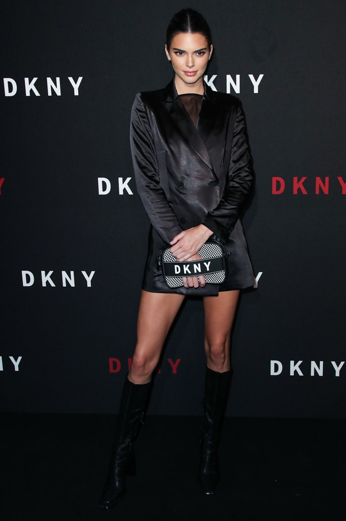 Kendall Jenner turned heads in a sleek black blazer dress and knee-high snake-embossed boots, showing off her long legs with no pants in sight