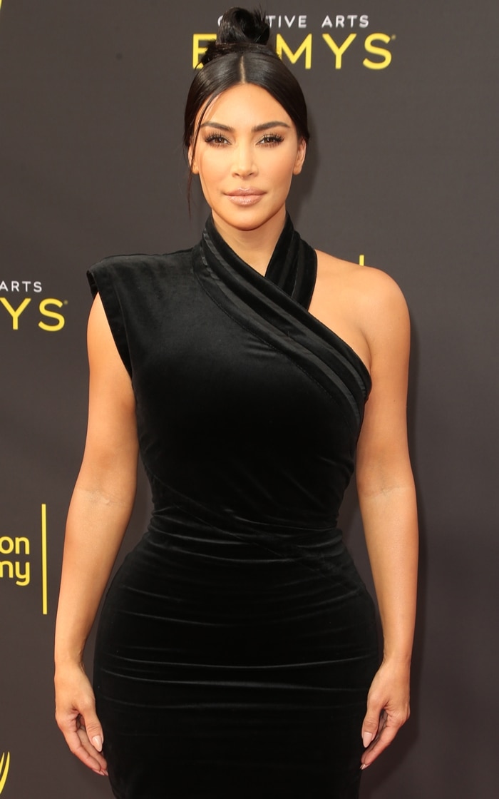 Kim Kardashian wearing an asymmetrical vintage Gianni Versace black velvet gown at the Creative Arts Emmys