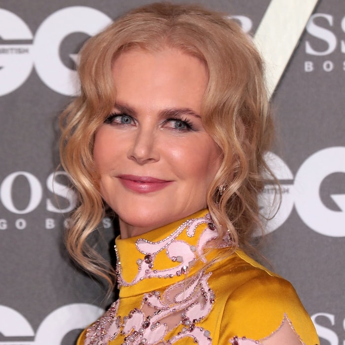 A soft, curled updo and natural makeup keep the focus on texture and color rather than competing with the statement dress