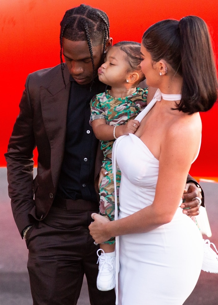 Stormi Webster stole the spotlight in an adorable camouflage-print outfit paired with crisp white mini sneakers, matching her mom Kylie Jenner’s sleek white dress and dad Travis Scott’s sharp brown suit