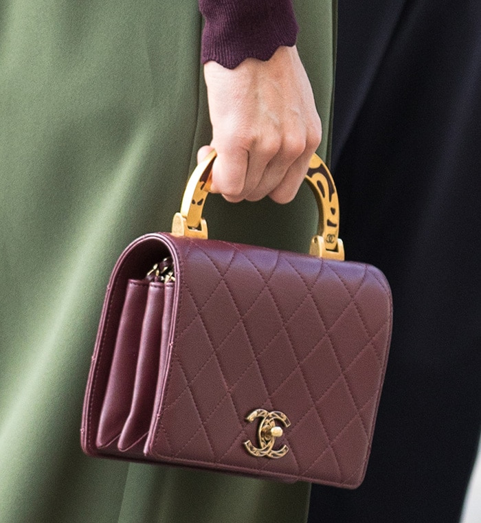 Kate Middleton carries Chanel’s burgundy Art Nouvelle Small Flap Bag, featuring diamond quilting, gold hardware, and a distinctive patterned enamel top handle
