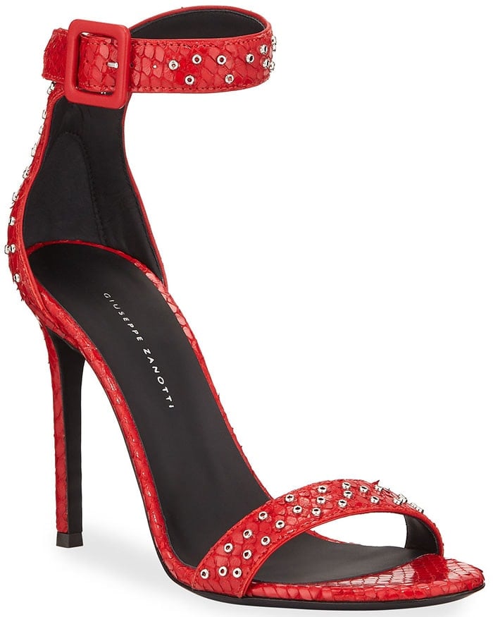 The red Giuseppe Zanotti sandals showcase snake-embossed leather, crystal-studded straps, and a sleek ankle cuff with a bold buckle, all set on a slender stiletto heel—original retail price $995