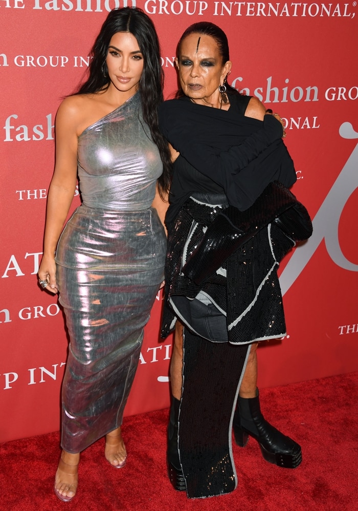 Kim Kardashian poses with Rick Owens’ wife, Michèle Lamy, at the 2019 FGI Night of Stars Gala—pairing a metallic one-shoulder Rick Owens gown with transparent Manolo Blahnik sandals