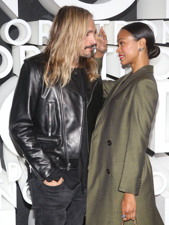 Zoe Saldaña shares a tender moment with husband Marco Perego, gently brushing his hair aside while the stylish pair attends Nordstrom’s Flagship Opening Party in New York City