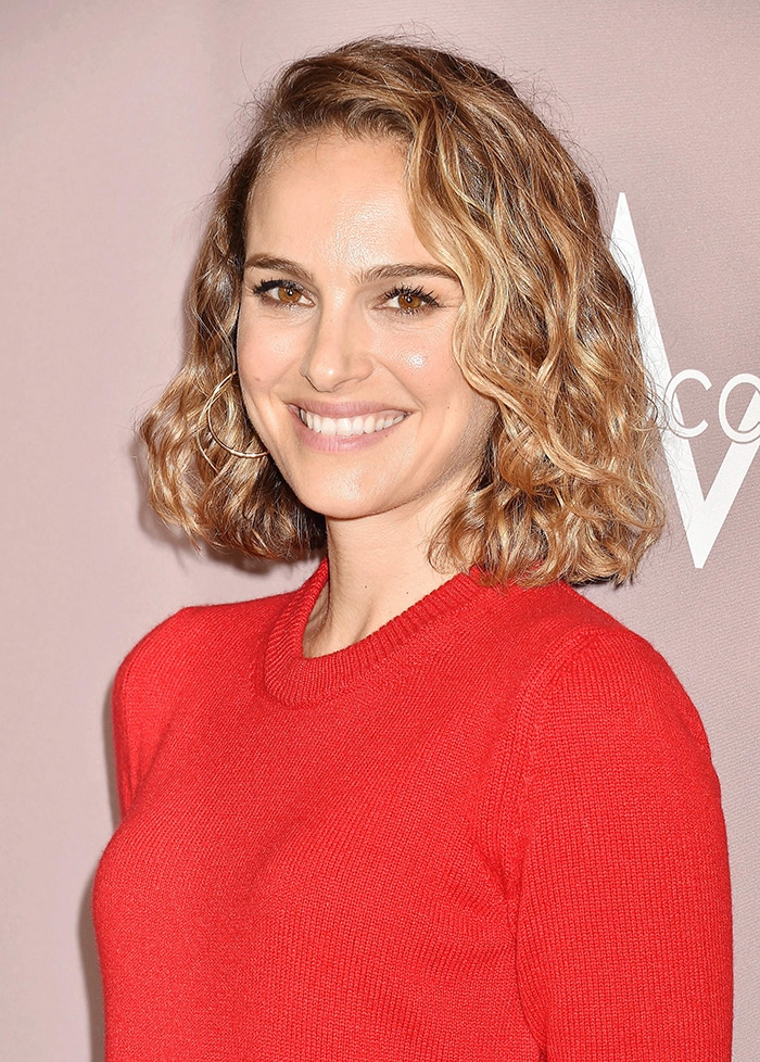 Natalie Portman wears her hair in side-swept curls and sports nude makeup