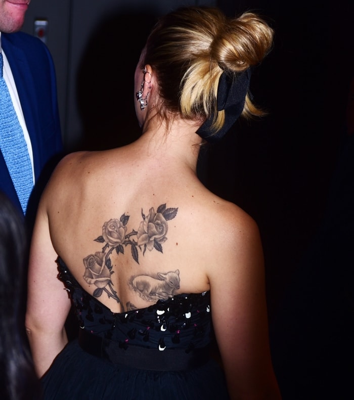 Scarlett Johansson's strapless Dior gown reveals the black-and-white floral tattoo spanning her upper back, styled with a voluminous bun tied with a black ribbon