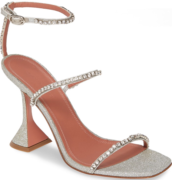 The glitter-finished silver version of the Amina Muaddi “Gilda” sandal highlighted the sculptural heel and crystal embellishments that helped launch the brand’s breakout red-carpet appeal
