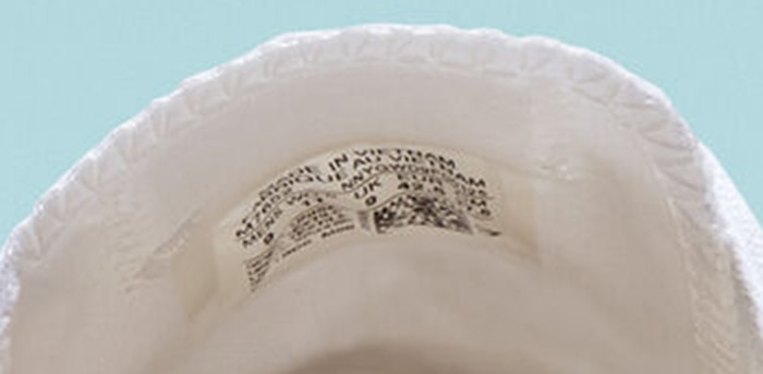Authentic Converse sneaker tongue featuring the inside patch with product details, size, and QR code