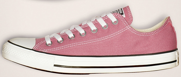 Authentic pink Converse Chuck Taylor All Star low-top featuring straight, solid paint along the rubber piping and classic white midsole