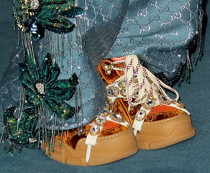 Her jeweled Gucci Flashtrek sneakers added a playful, high-glam twist beneath the heavily embellished trousers, anchoring the outfit in her unmistakable offbeat style