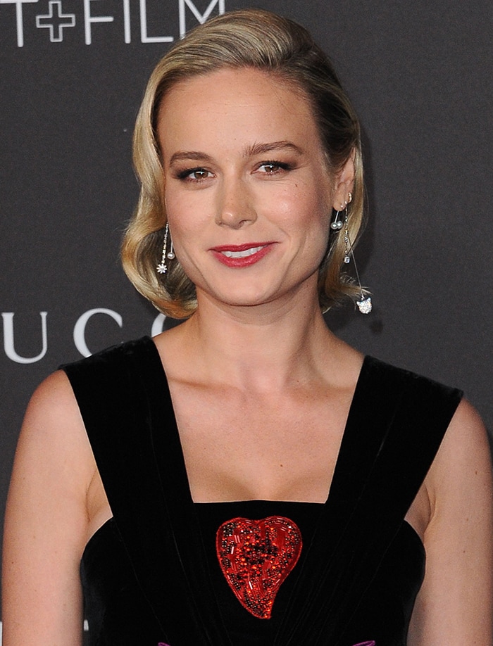 Soft waves and delicate drop earrings give Brie Larson’s look a vintage, romantic finish that complements the gown’s whimsical detailing