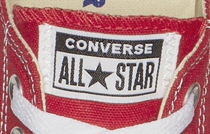 Red low-top Converse Chuck Taylor All Star featuring a black-and-white tongue logo patch with star detail