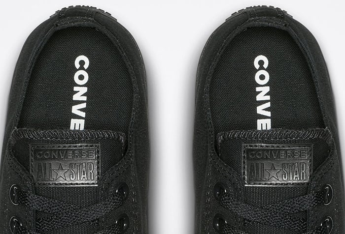 Authentic black monochrome Converse Chuck Taylor All Star sneakers featuring tonal “CONVERSE” insoles and matching black logo patches
