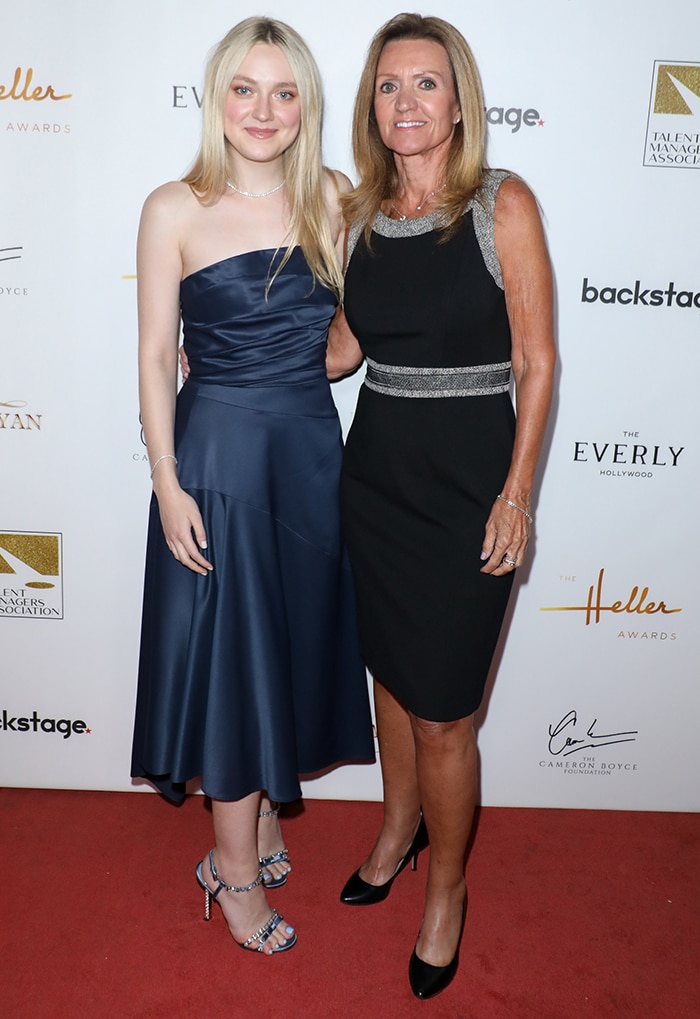 Dakota Fanning poses with her former agent Cindy Osbrink at the 2019 Heller Awards, pairing a strapless navy Narciso Rodriguez midi dress with crystal-embellished blue Prada sandals for a polished red-carpet look