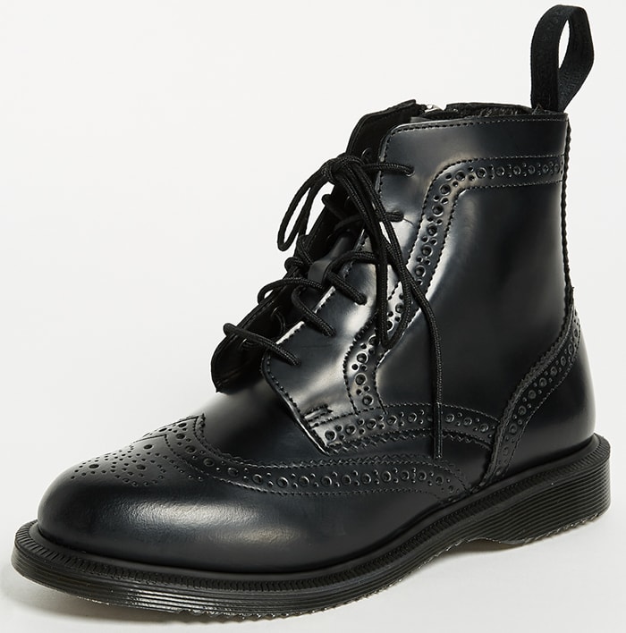 The Dr. Martens “Delphine” brogue boots combine classic wingtip detailing with the brand’s signature chunky sole, delivering a polished yet rebellious take on lace-up ankle boots