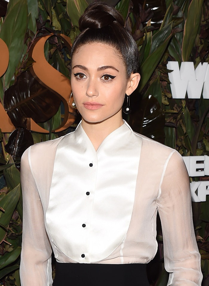 Wearing her hair in a sleek topknot and bold winged liner, Rossum lets her minimalist Armani look take center stage