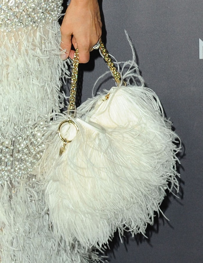 She completes the look with a white feather Jimmy Choo clutch featuring a gold-tone chain handle for added texture and contrast
