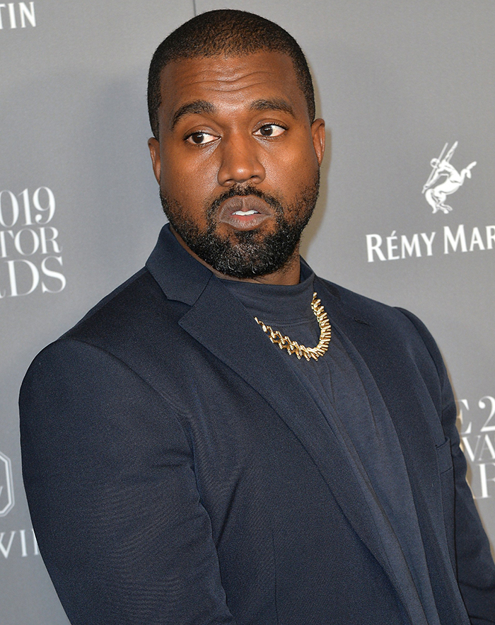 Kanye West wears a navy Burberry suit with tall blue galoshes at the WSJ Innovator Awards