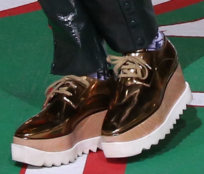 Kelly Rowland grounded her oversized winter rehearsal look with metallic gold Stella McCartney “Elyse” platform shoes, featuring chunky wooden wedges and serrated rubber soles that added height without sacrificing comfort