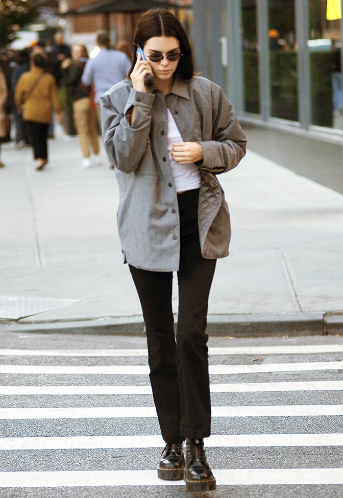 Kendall Jenner teams her Dr. Martens boots with gray jacket, white top, and black pants