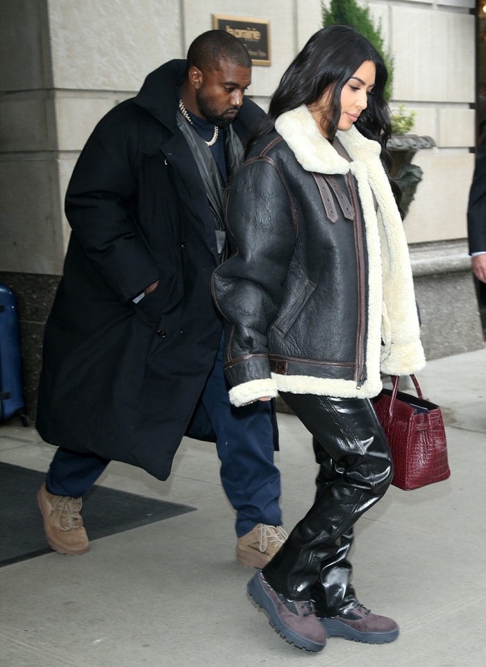 Kim Kardashian steps out in New York City on November 7, 2019, pairing an oversized shearling-lined leather aviator jacket and Helmut Lang patent trousers with rugged Yeezy 950 boots and a burgundy crocodile Hermès Birkin bag
