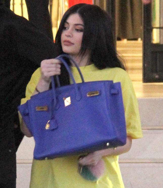 Kylie Jenner holds up her blue Hermès Birkin bag while shopping at Barneys New York in 2016