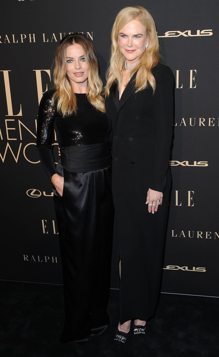 Nicole Kidman and Margot Robbie pose side by side at the Women in Hollywood Celebration, with Kidman visibly towering in sleek black tailoring and statement heels