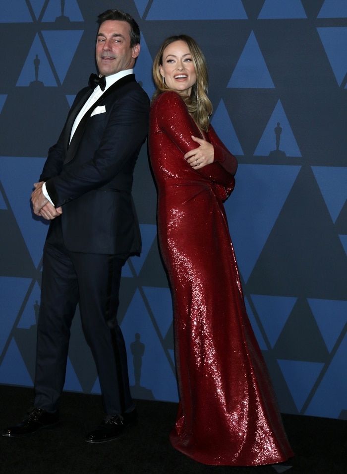 Jon Hamm and Olivia Wilde strike a playful, back-to-back pose at the 11th Annual Governors Awards, where Wilde’s sleek red sequined gown and heels amplify her frame alongside Hamm at the Ray Dolby Ballroom in Hollywood