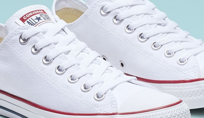 Authentic white Converse Chuck Taylor All Star low-tops featuring sturdy double stitching on the canvas upper and polished metal eyelets