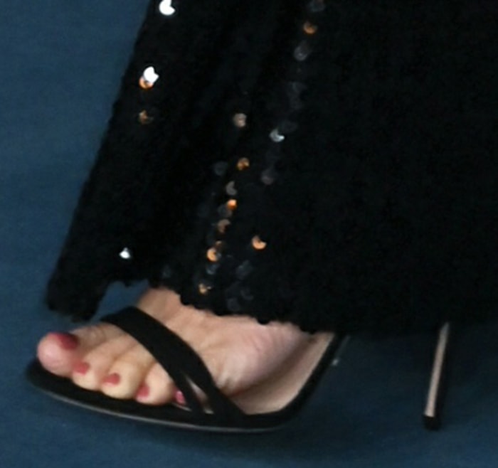 She completed the ensemble with classic black Gucci sandals, revealing a polished red pedicure beneath the floor-length sequins