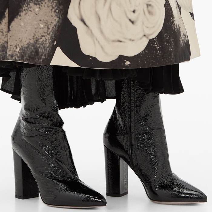 A creased patent-leather finish gives Valentino’s pointed Ringstud boots a glossy, textured appearance