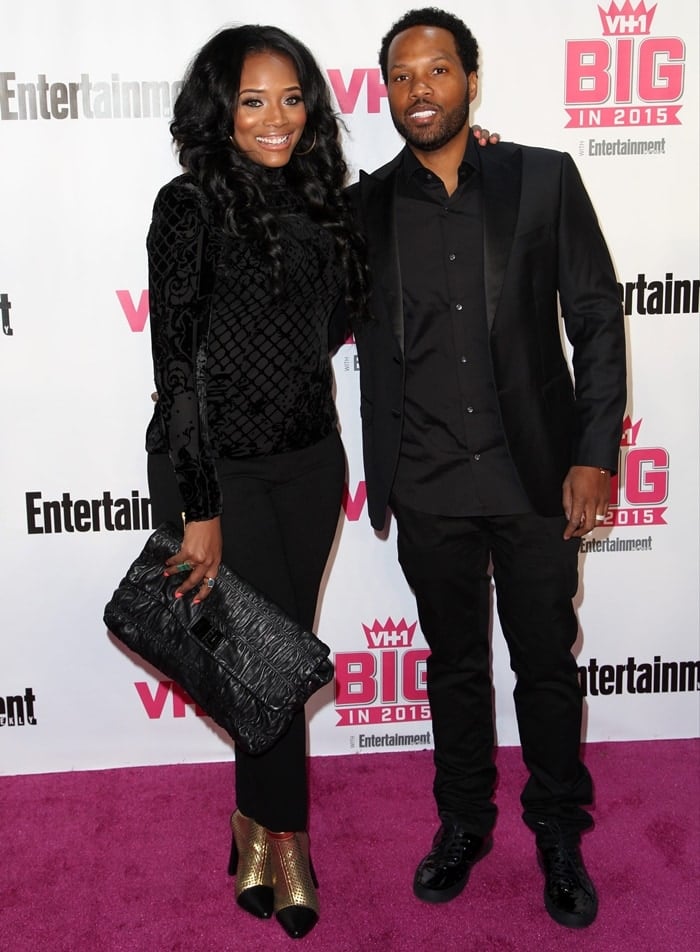 Yandy Smith and Mendeecees Harris coordinate in black at VH1 Big in 2015, with her metallic gold ankle boots and oversized textured clutch adding shine to the monochromatic look