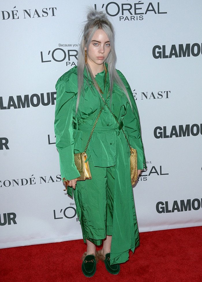 Billie Eilish pairs a voluminous Craig Green ensemble with plush green Gucci slides, letting their relaxed, backless silhouette soften the look’s structure at the 2017 Women of the Year Awards on November 14, 2017
