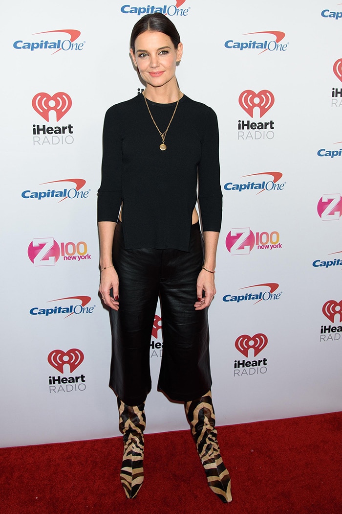 Katie Holmes balanced cropped black leather culottes with zebra-print Khaite slouch boots, letting the pointed toes and softly ruched shafts become the focus of her otherwise minimal concert look