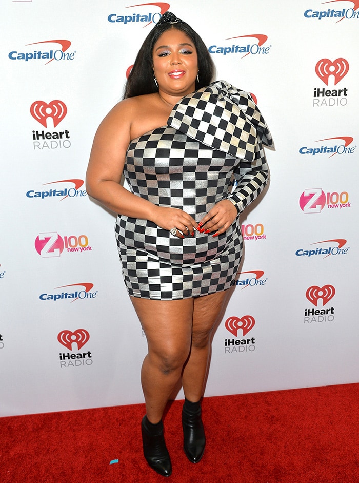 Lizzo wears a silver-and-black Christian Siriano checked mini dress with black ankle boots at the 2019 Z100 Jingle Ball