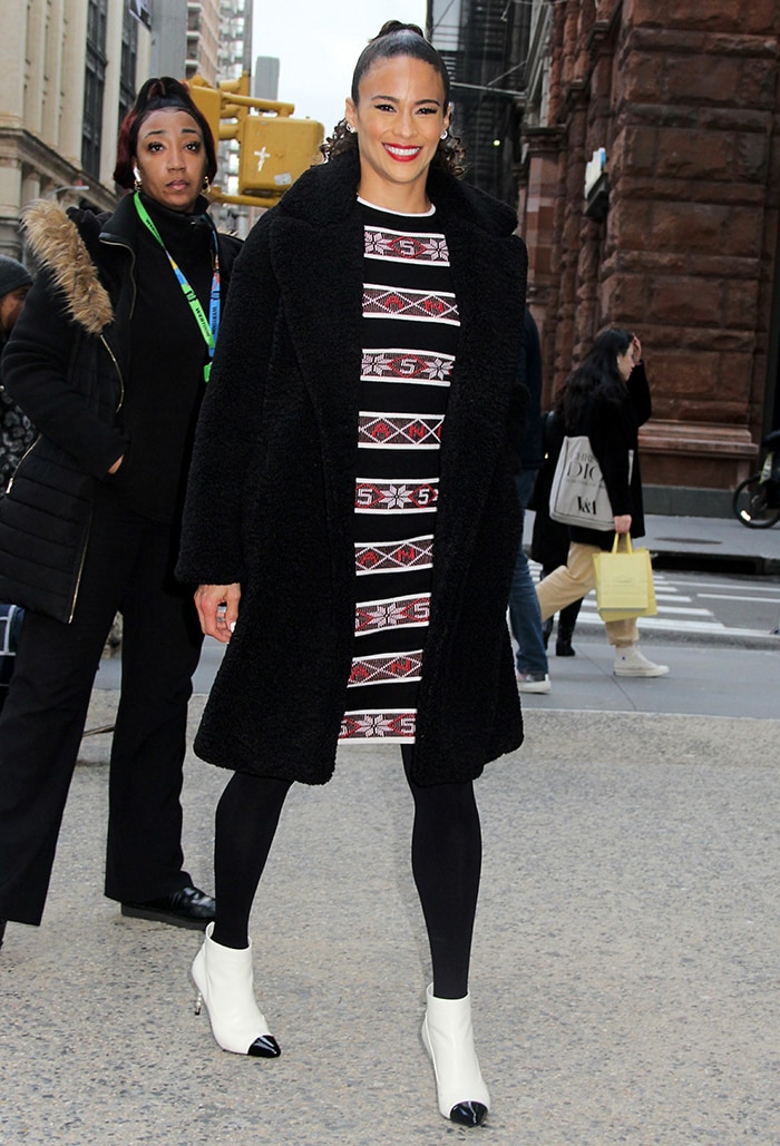 Paula Patton steps out in a black shearling coat layered over a striped Chanel Resort 2020 dress, pairing the cozy look with opaque tights and her signature two-tone Chanel ankle boots