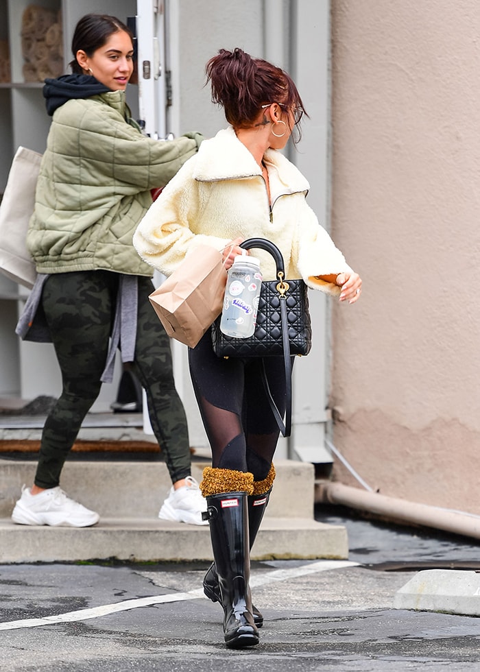 Sarah Hyland wearing Alo mesh-panel leggings and tall black Hunter rain boots in Los Angeles