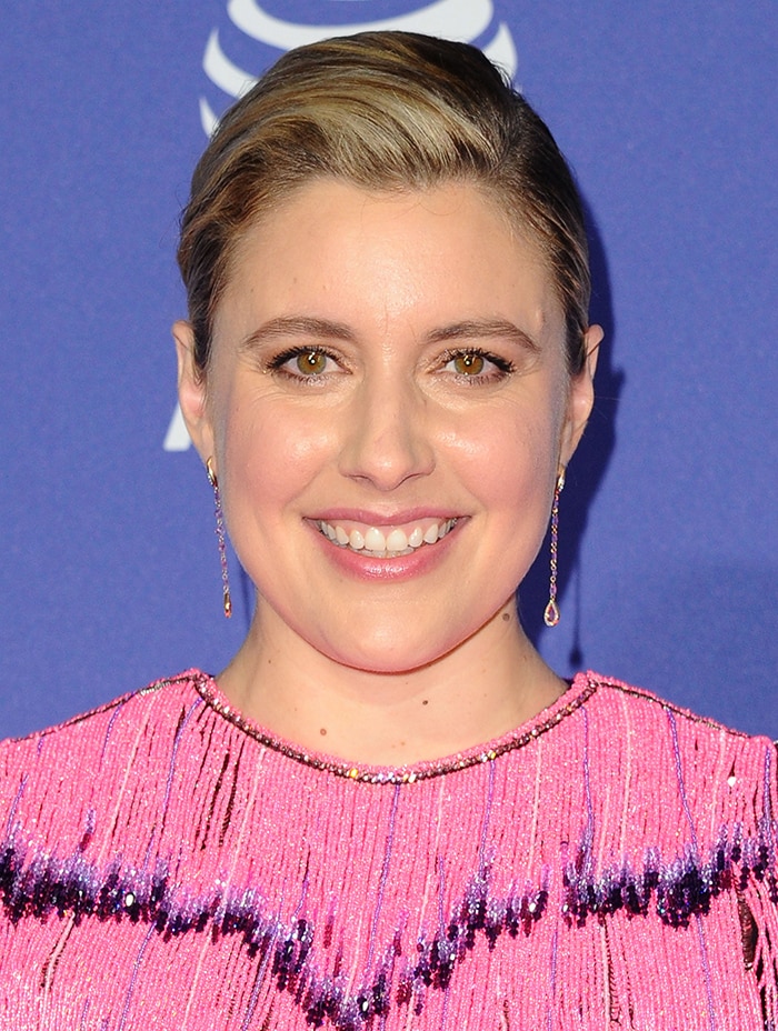 With her hair slicked back and minimal makeup, Greta Gerwig lets the vibrant beadwork and delicate drop earrings frame her face