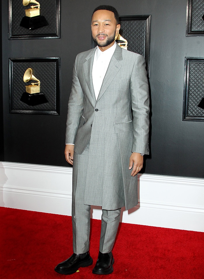 John Legend embraced Alexander McQueen's directional tailoring in a gray coat-style suit finished with substantial black Chelsea boots instead of traditional dress shoes