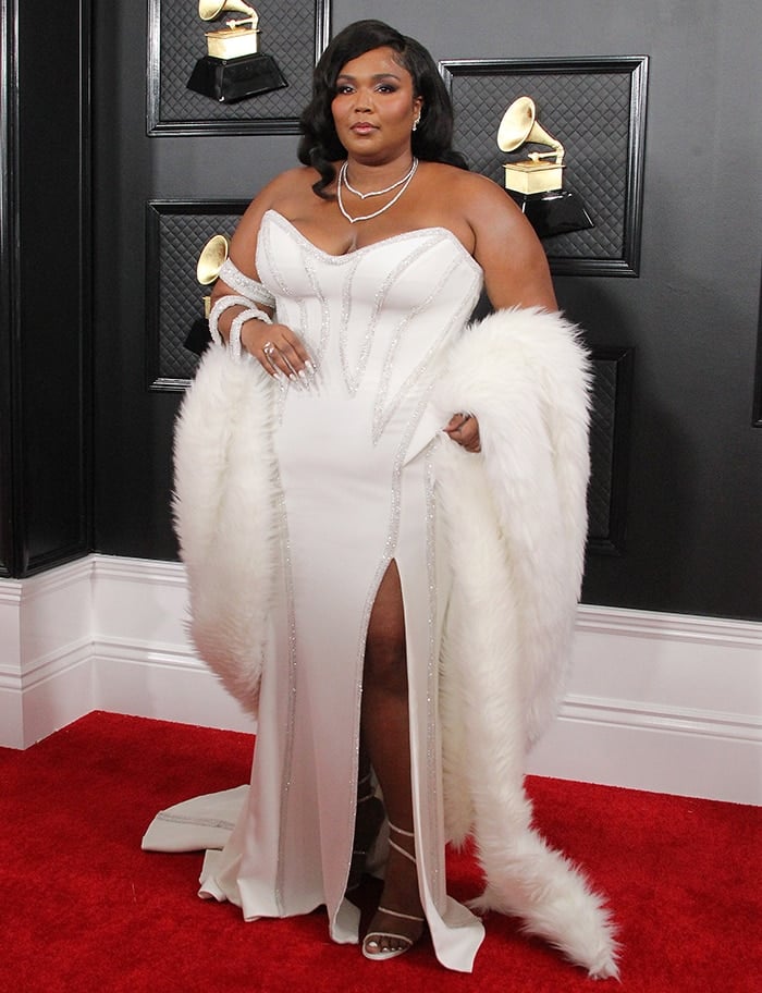 Lizzo channels old Hollywood glamour in a custom white Atelier Versace gown with a sweeping faux-fur stole and crystal-wrapped René Caovilla Cleo sandals at the 62nd Grammy Awards