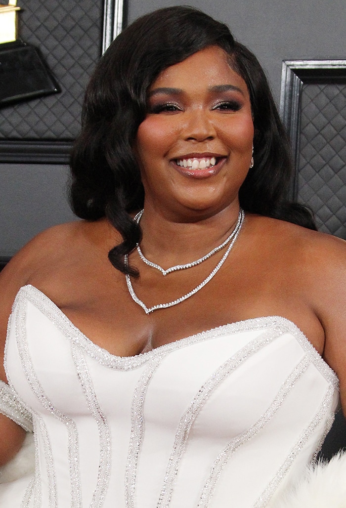 Soft vintage waves, shimmering purple smoky eyes, and layered Lorraine Schwartz diamonds completed Lizzo's elegant Grammy red carpet look