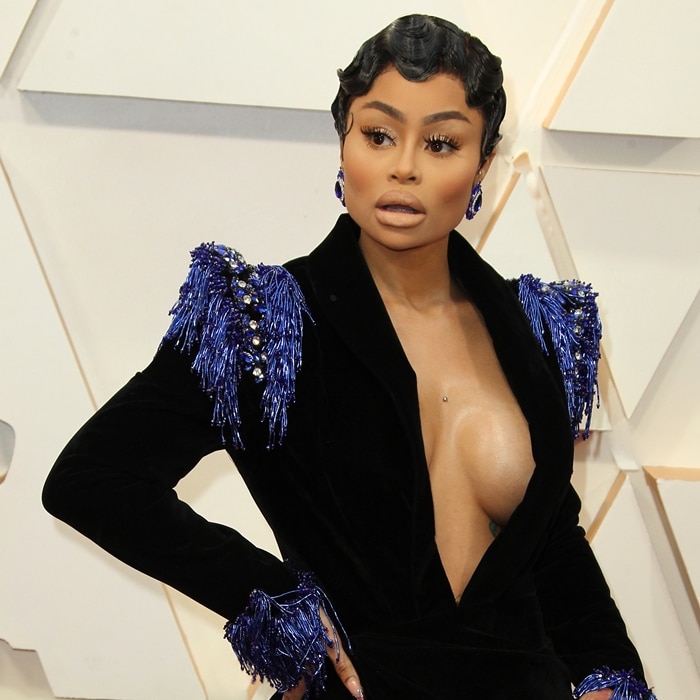Blac Chyna styled her finger-wave pixie hairstyle with sapphire-toned earrings and a plunging black velvet gown trimmed with crystal-fringed shoulders at the 92nd Academy Awards