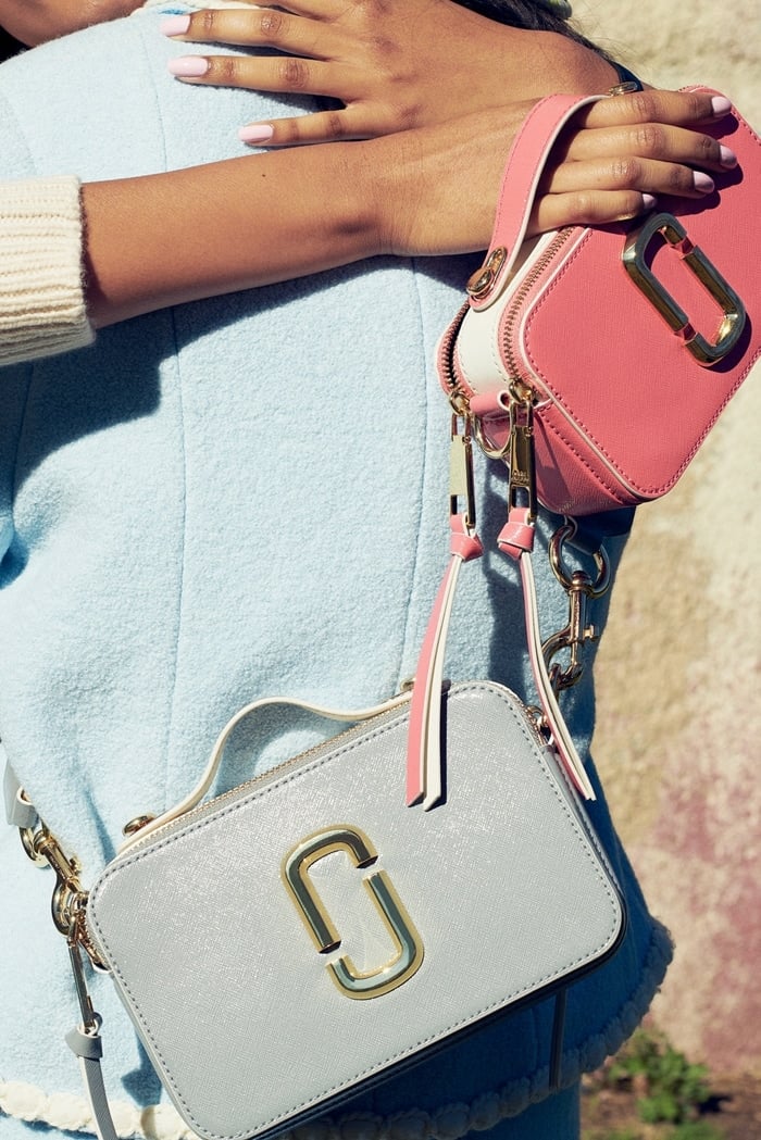 Camera-style bag in Saffiano leather with a top handle, two-zip sections, and an adjustable crossbody strap