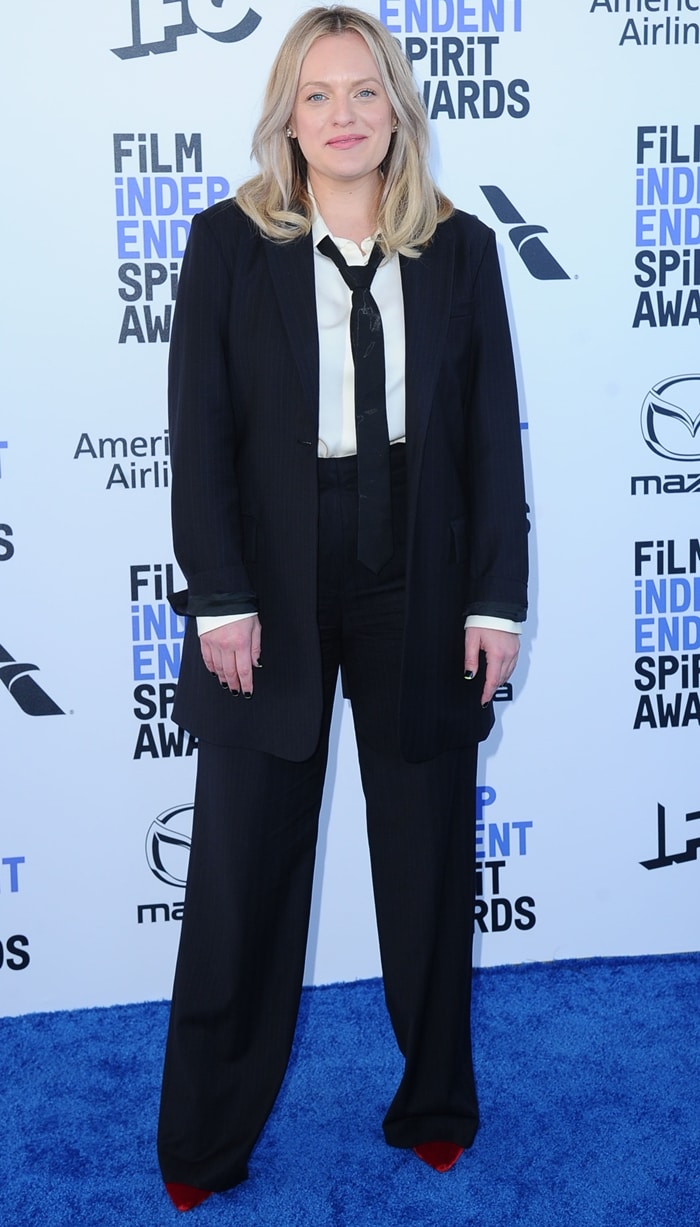Just weeks earlier in Santa Monica, Moss took a sharply different approach, grounding a relaxed black Co suit with striking red Jimmy Choo heels that peeked out beneath the wide-leg trousers