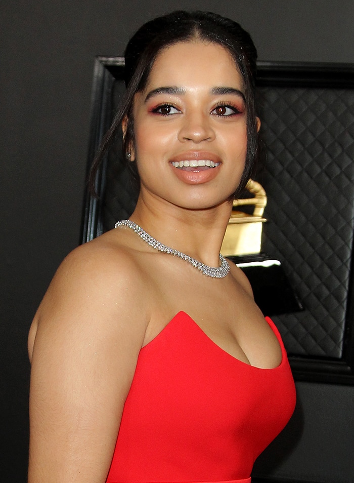 Ella Mai complements her red Giorgio Armani gown with softly blended red-toned eyeshadow and a radiant, warm makeup look