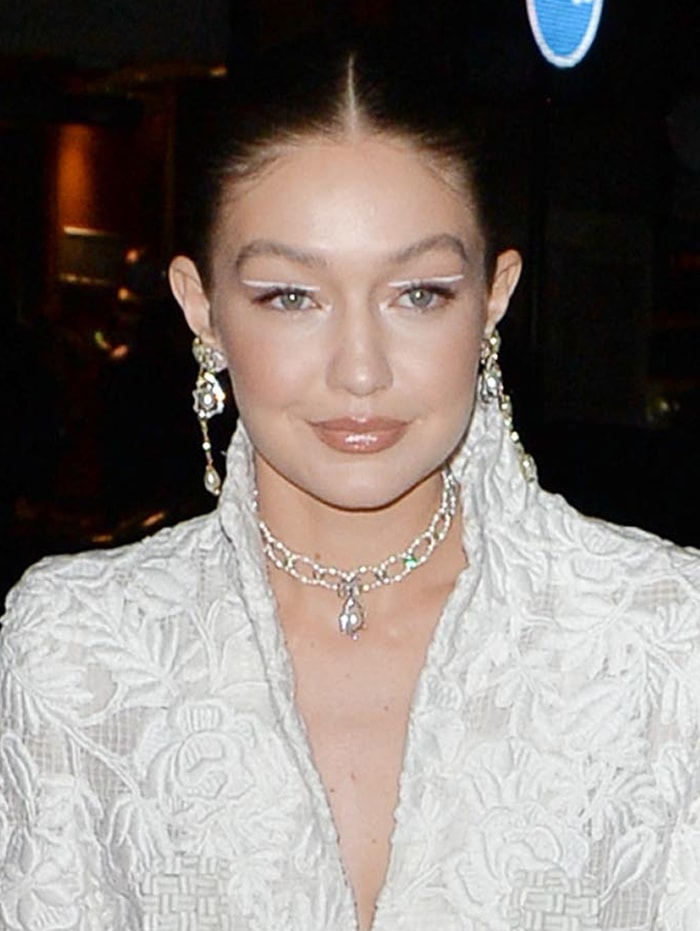 Gigi Hadid complemented her sleek braided bun and graphic white eyeliner with diamond drop earrings and a layered Chanel necklace