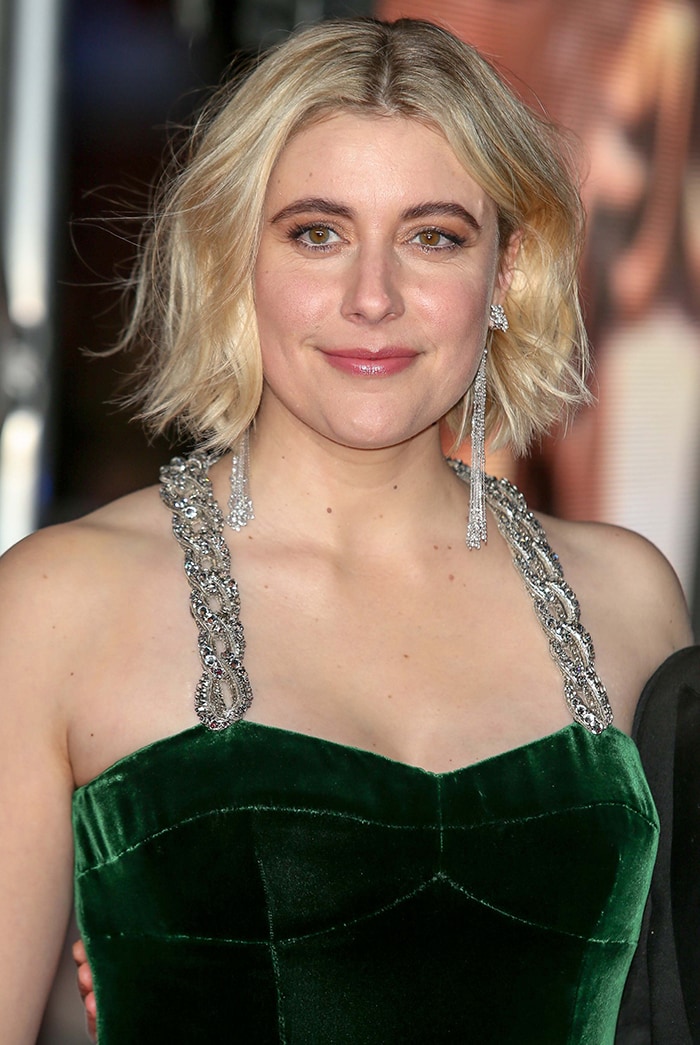 Greta Gerwig pairs her velvet Gucci gown with a tousled blonde bob and soft pink makeup, letting the crystal-embellished straps steal the spotlight at the 2020 BAFTAs