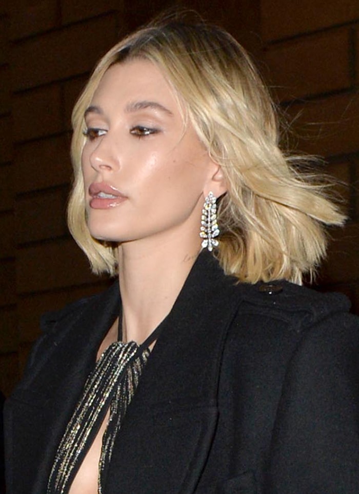 Hailey Bieber wears nude lip gloss and black mascara with tousled hairstyle