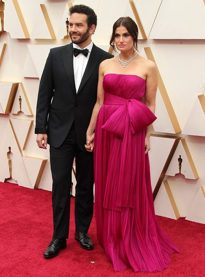 Aaron Lohr and Idina Menzel hold hands as they walk the 2020 Oscars red carpet in Los Angeles on February 9, 2020